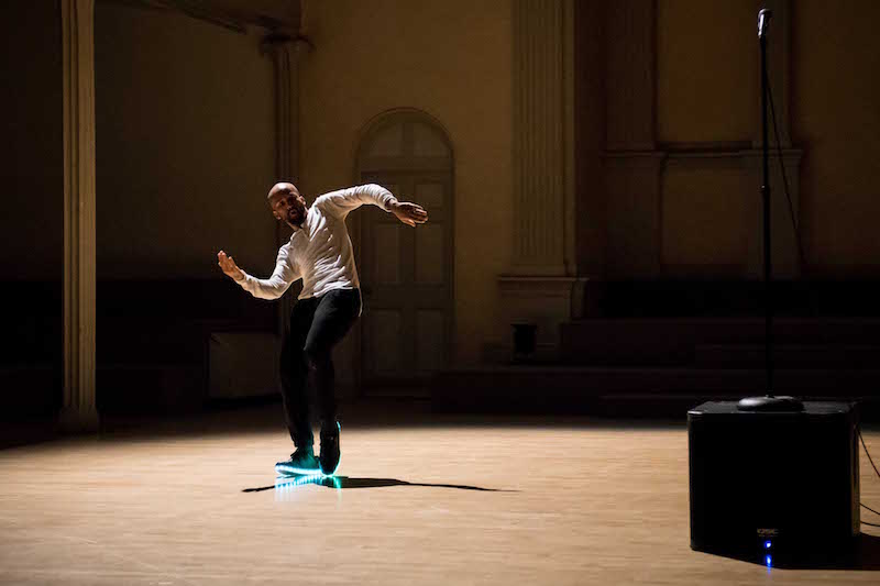 Jonathan Gonzalez in a white shirt and black sneakers performs in light up sneakers